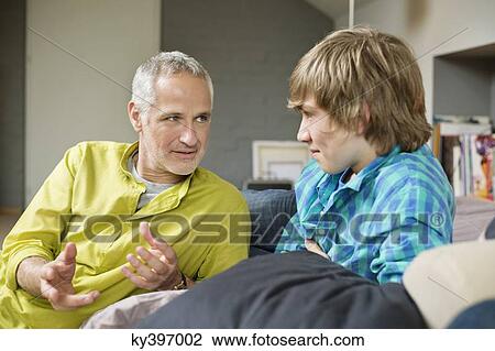 Stock Image - Man talking with his son at home. Fotosearch
