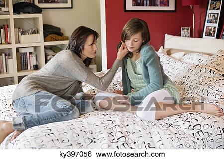Woman consoling her sad daughter in the bedroom View Large Photo Image Stock Photograph - Woman consoling her sad daughter in the bedroom. Fotosearch