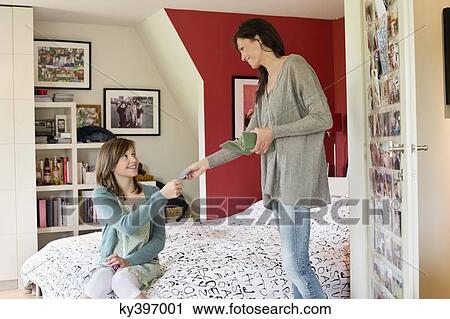 Woman giving pocket money to her daughter View Large Photo Image Stock Image - Woman giving pocket money to her daughter. Fotosearch