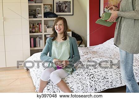 Woman giving pocket money to her daughter View Large Photo Image Stock Photo - Woman giving pocket money to her daughter. Fotosearch