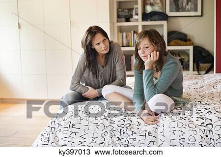 Woman looking at her sad daughter in the bedroom View Large Photo Image Stock Image - Woman looking at her sad daughter in the bedroom. Fotosearch