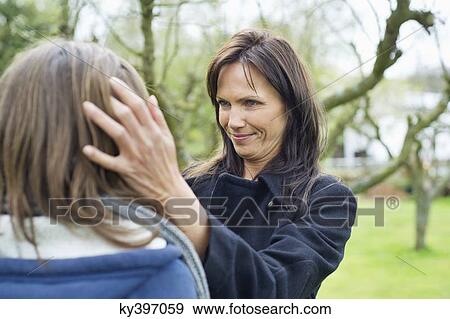 Woman pamper her daughter in a park View Large Photo Image Stock Photo - Woman pamper her daughter in a park. Fotosearch