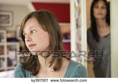 Stock Photo - Woman watching her daughter behind the door in the bedroom. Fotosearch