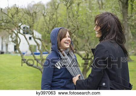 Woman with her daughter having fun in an orchard View Large Photo Image Stock Image - Woman with her daughter having fun in an orchard. Fotosearch