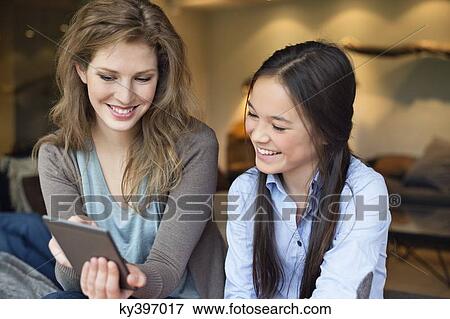 Woman with her daughter using digital tablet View Large Photo Image Stock Photo - Woman with her daughter using digital tablet. Fotosearch