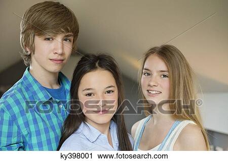 Portrait of a teenage boy with his two sisters smiling View Large Photo Image Stock Image - Portrait of a teenage boy with his two sisters smiling. Fotosearch