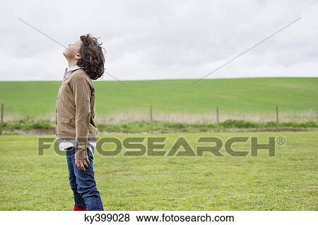 Boy daydreaming in a field View Large Photo Image Stock Photo - Boy daydreaming in a field. Fotosearch