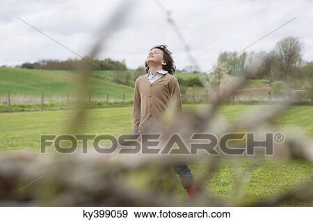 Boy daydreaming in a field View Large Photo Image Stock Photo - Boy daydreaming in a field. Fotosearch