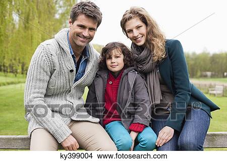 Boy sitting with his parents on the gate of a cottage View Large Photo Image Picture - Boy sitting with his parents on the gate of a cottage. Fotosearch