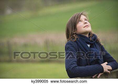Girl looking up in a farm View Large Photo Image Stock Photography - Girl looking up in a farm. Fotosearch