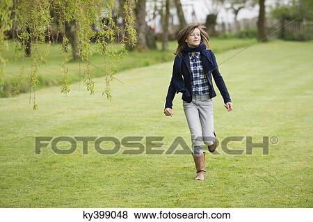 Girl running in a field View Large Photo Image Stock Photo - Girl running in a field. Fotosearch
