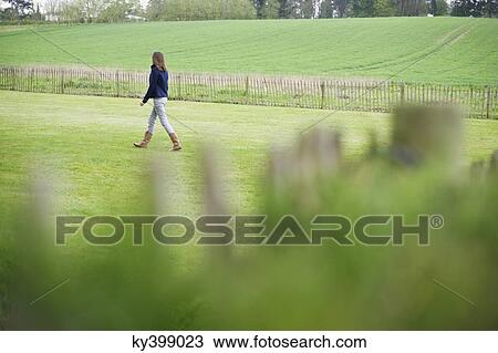 Girl walking in a field View Large Photo Image Stock Image - Girl walking in a field. Fotosearch
