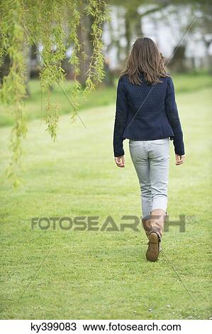 Girl walking in a field View Large Photo Image Stock Image - Girl walking in a field. Fotosearch