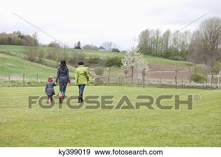 Girl walking with her mother and grandmother in a lawn View Large Photo Image Stock Photo - Girl walking with her mother and grandmother in a lawn. Fotosearch
