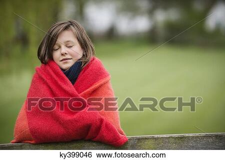 Girl wrapped in a blanket with her eyes closed in a farm View Large Photo Image Stock Photograph - Girl wrapped in a blanket with her eyes closed in a farm. Fotosearch