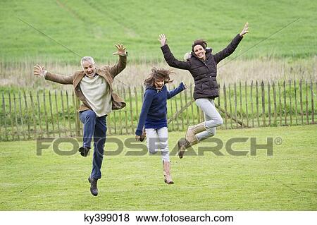 Happy family having fun in a field View Large Photo Image Stock Photo - Happy family having fun in a field. Fotosearch