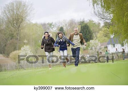 Stock Photo - Happy family running in a field. Fotosearch