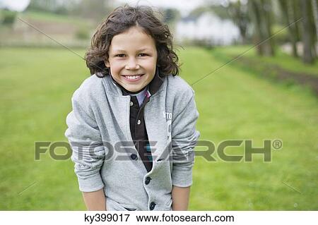 Portrait of a boy smiling in a field View Large Photo Image Stock Photo - Portrait of a boy smiling in a field. Fotosearch