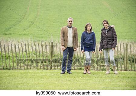 Portrait of a happy family standing in a field View Large Photo Image Stock Image - Portrait of a happy family standing in a field. Fotosearch