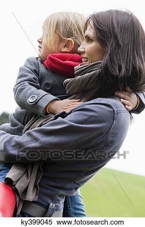 Stock Photography - Woman carrying her daughter. Fotosearch