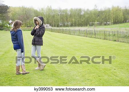 Woman with her daughter standing in a field View Large Photo Image Stock Image - Woman with her daughter standing in a field. Fotosearch