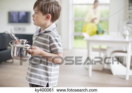 Stock Image - Boy carrying a saucepan. Fotosearch