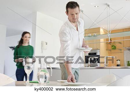 Stock Image - Couple preparing to serve dinner. Fotosearch