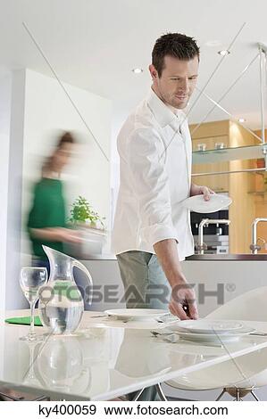 Couple preparing to serve dinner View Large Photo Image Stock Photo - Couple preparing to serve dinner. Fotosearch