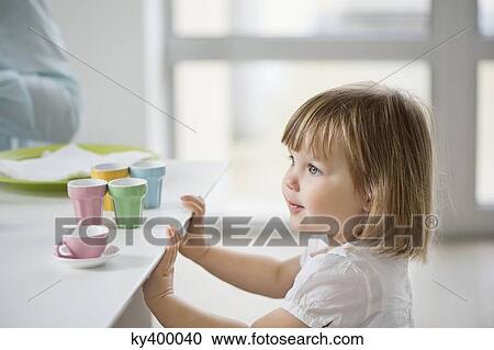 Cute girl with toy tea set near a dining table View Large Photo Image Stock Image - Cute girl with toy tea set near a dining table. Fotosearch