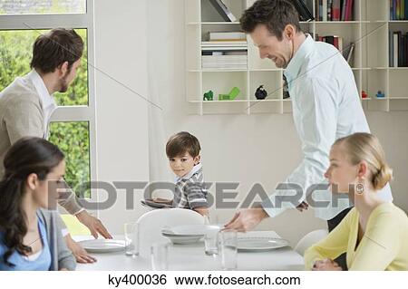 Family and guests at dining table for lunch View Large Photo Image Stock Photograph - Family and guests at dining table for lunch. Fotosearch