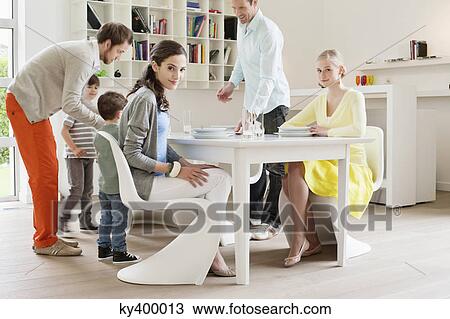 Family at dining table with guests View Large Photo Image Stock Image - Family at dining table with guests. Fotosearch