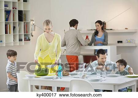 Stock Photo - Family setting table for dinner. Fotosearch