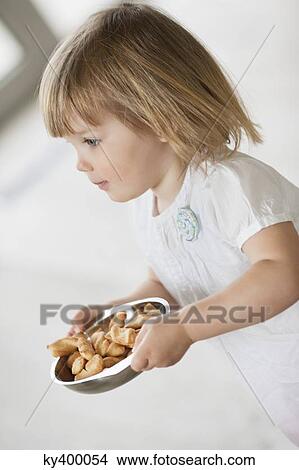 Girl carrying a bowl of food View Large Photo Image Picture - Girl carrying a bowl of food. Fotosearch