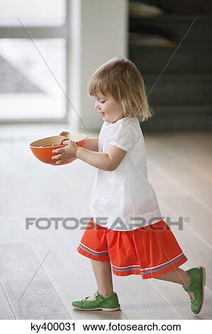 Girl carrying a bowl of food View Large Photo Image Stock Image - Girl carrying a bowl of food. Fotosearch