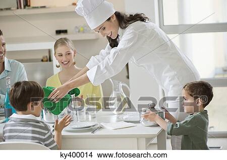 Little boy assisting his mother in serving dinner View Large Photo Image Picture - Little boy assisting his mother in serving dinner. Fotosearch