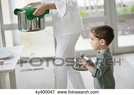 Stock Photo - Little boy assisting his mother in serving food. Fotosearch