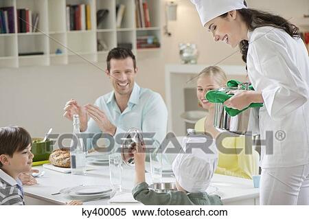 Little boy assisting his mother in serving dinner View Large Photo Image Stock Photography - Little boy assisting his mother in serving dinner. Fotosearch