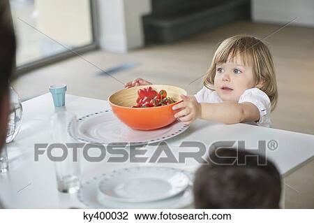 Little girl placing fruit bowl on dining table View Large Photo Image Stock Image - Little girl placing fruit bowl on dining table. Fotosearch