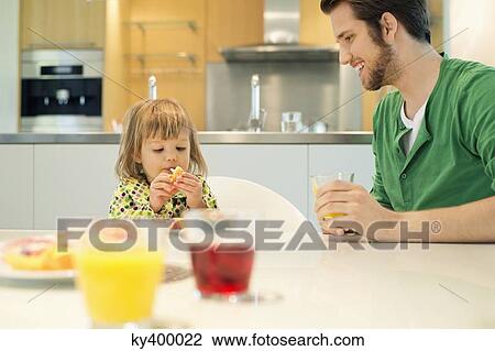 Man and daughter at breakfast table View Large Photo Image Stock Image - Man and daughter at breakfast table. Fotosearch