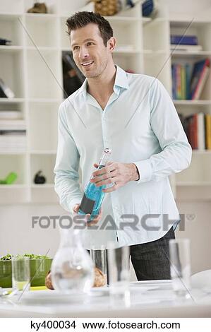 Picture - Man holding a sparkling water bottle. Fotosearch