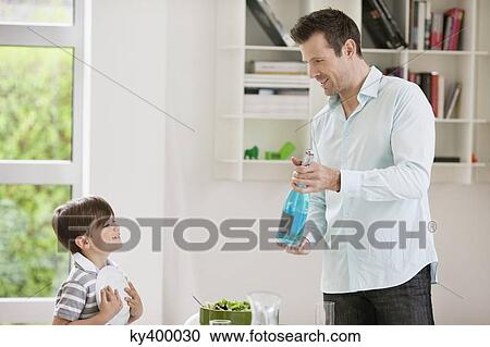 Man showing sparkling water bottle to his son View Large Photo Image Stock Image - Man showing sparkling water bottle to his son. Fotosearch