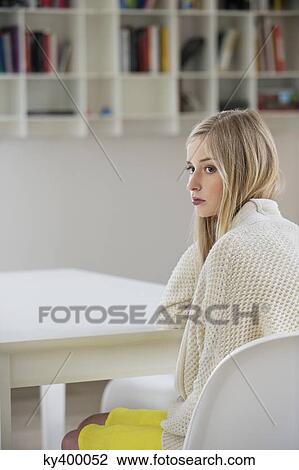 Serious woman sitting in a room View Large Photo Image Stock Image - Serious woman sitting in a room. Fotosearch