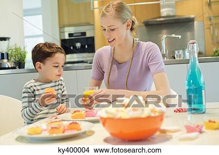 Woman and son at breakfast table View Large Photo Image Picture - Woman and son at breakfast table. Fotosearch