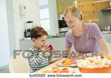 Stock Image - Woman and son at breakfast table. Fotosearch