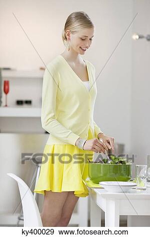 Woman mixing salad at a dining table View Large Photo Image Stock Photo - Woman mixing salad at a dining table. Fotosearch