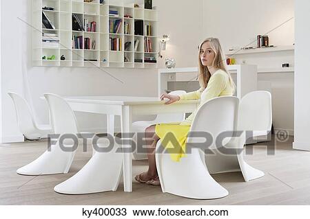 Woman sitting at a dining table View Large Photo Image Stock Image - Woman sitting at a dining table. Fotosearch