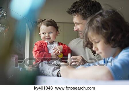 Close-up of a man with his children at home View Large Photo Image Stock Image - Close-up of a man with his children at home. Fotosearch