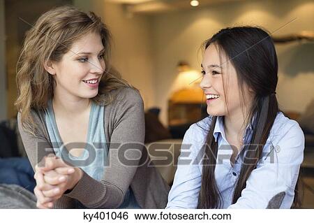 Close-up of a woman smiling with her daughter View Large Photo Image Stock Photograph - Close-up of a woman smiling with her daughter. Fotosearch