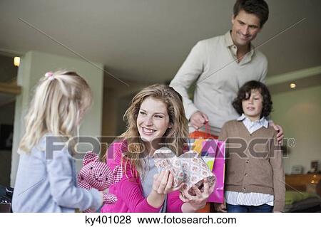 Stock Photo - Girl giving surprise gift to her mother on mother day. Fotosearch