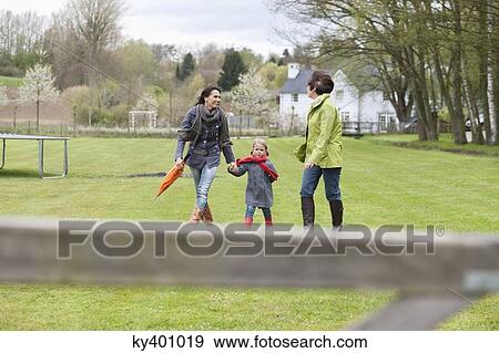 Girl walking with her mother and grandmother in a lawn View Large Photo Image Stock Photo - Girl walking with her mother and grandmother in a lawn. Fotosearch